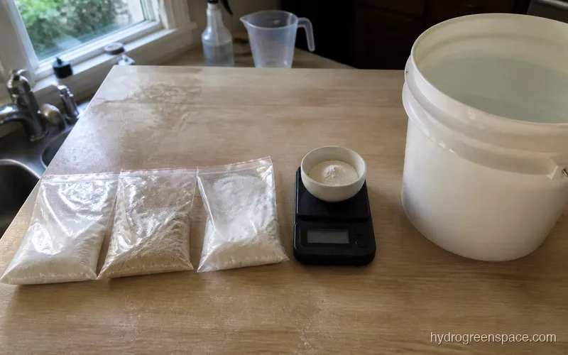 Three labeled bags of Masterblend 4-18-38, calcium nitrate, and Epsom salt next to a digital gram scale and 5-gallon water bucket